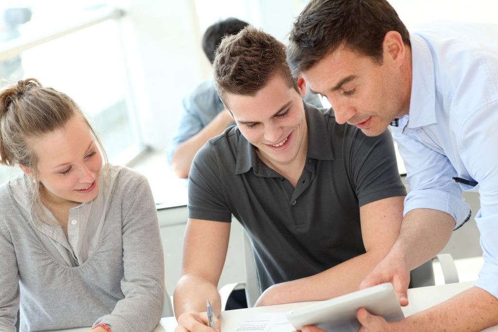 Teacher,helping,students,with,assignment
