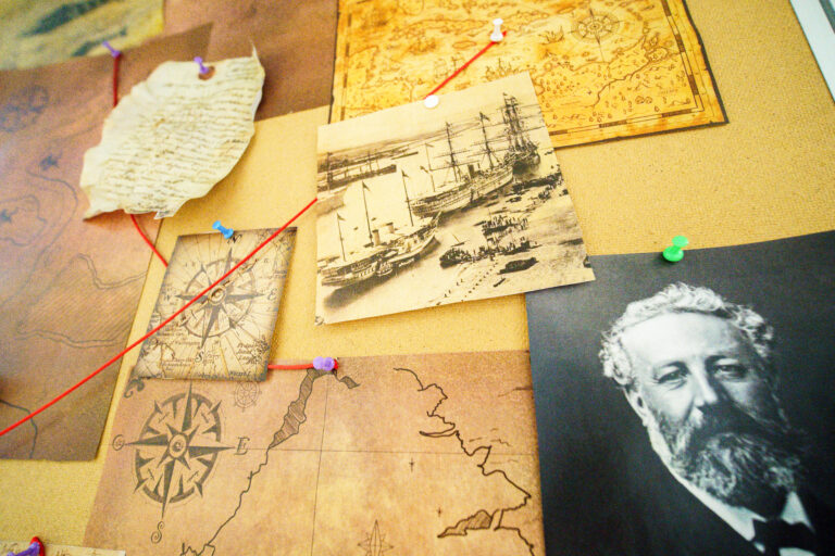Mur affichant plusieurs visuels, photos, cartes reliées par un fil rouge.